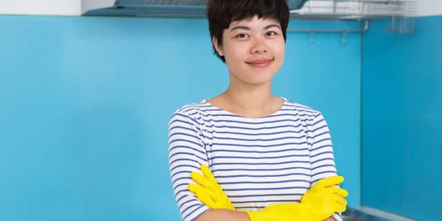 Smiling asian woman wearing protective gloves